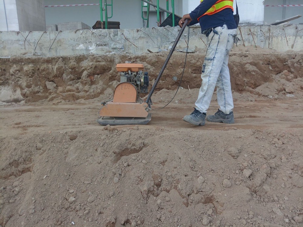 Plate compactor compacting aggregate base before paver installation