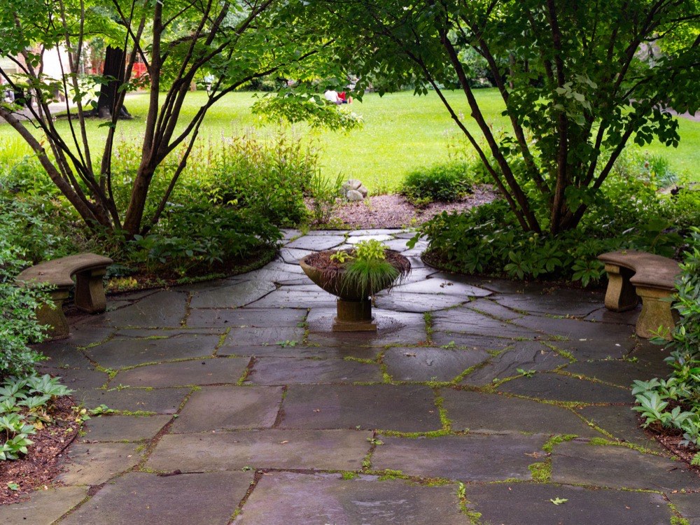 Flagstone patio surrounded by mature garden planting